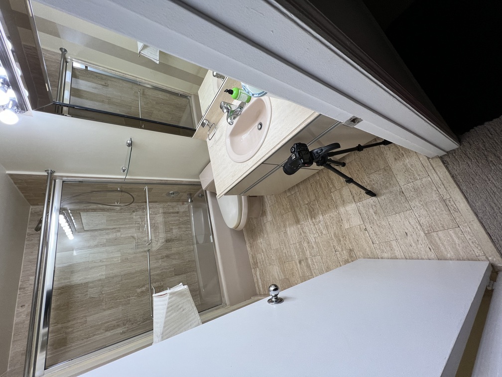 an interchangeable lens camera on a short tripod on a bathroom floor
