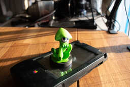 a green squid figurine on an apple newton